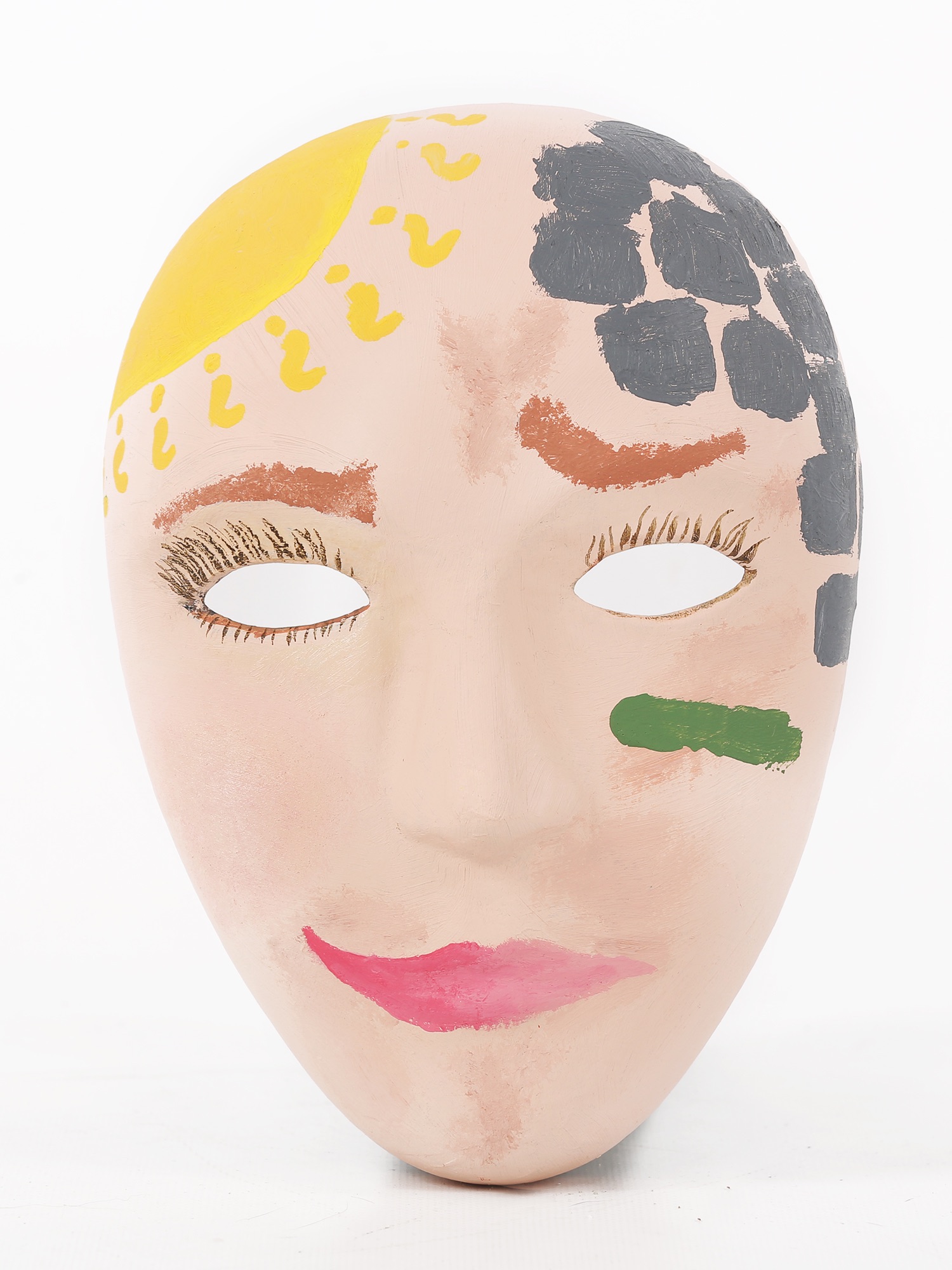 A mask painted like a woman's face, with what appear to be bricks covering the left side of her head and a sun on the right side.